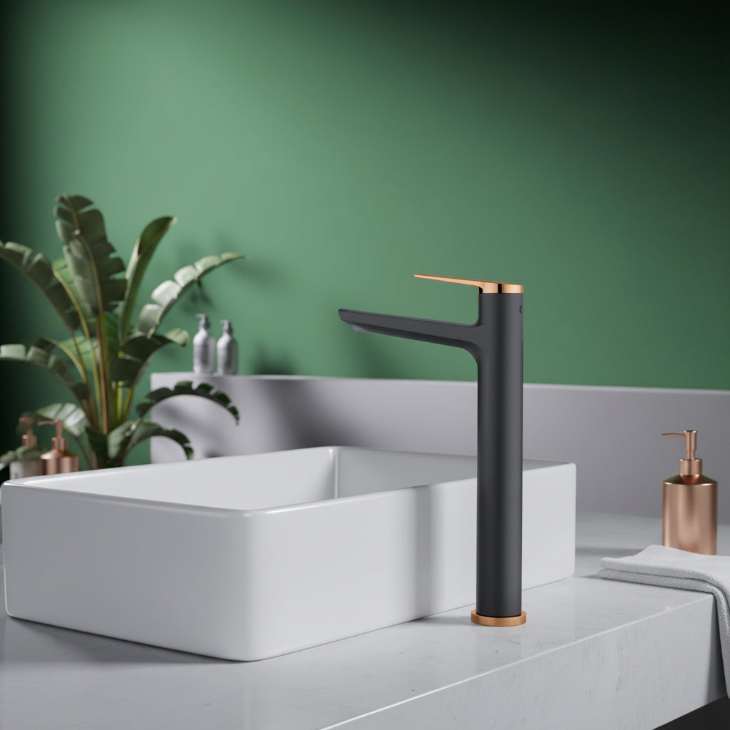 A matte black single-handle bathroom faucet with rose gold accents, shown installed next to a white vessel sink on a light gray countertop against a green wall.